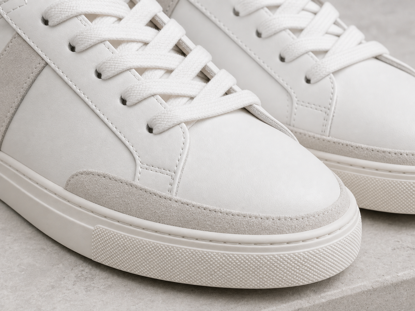 Close detail of pristine white trainer laces, leather and sole